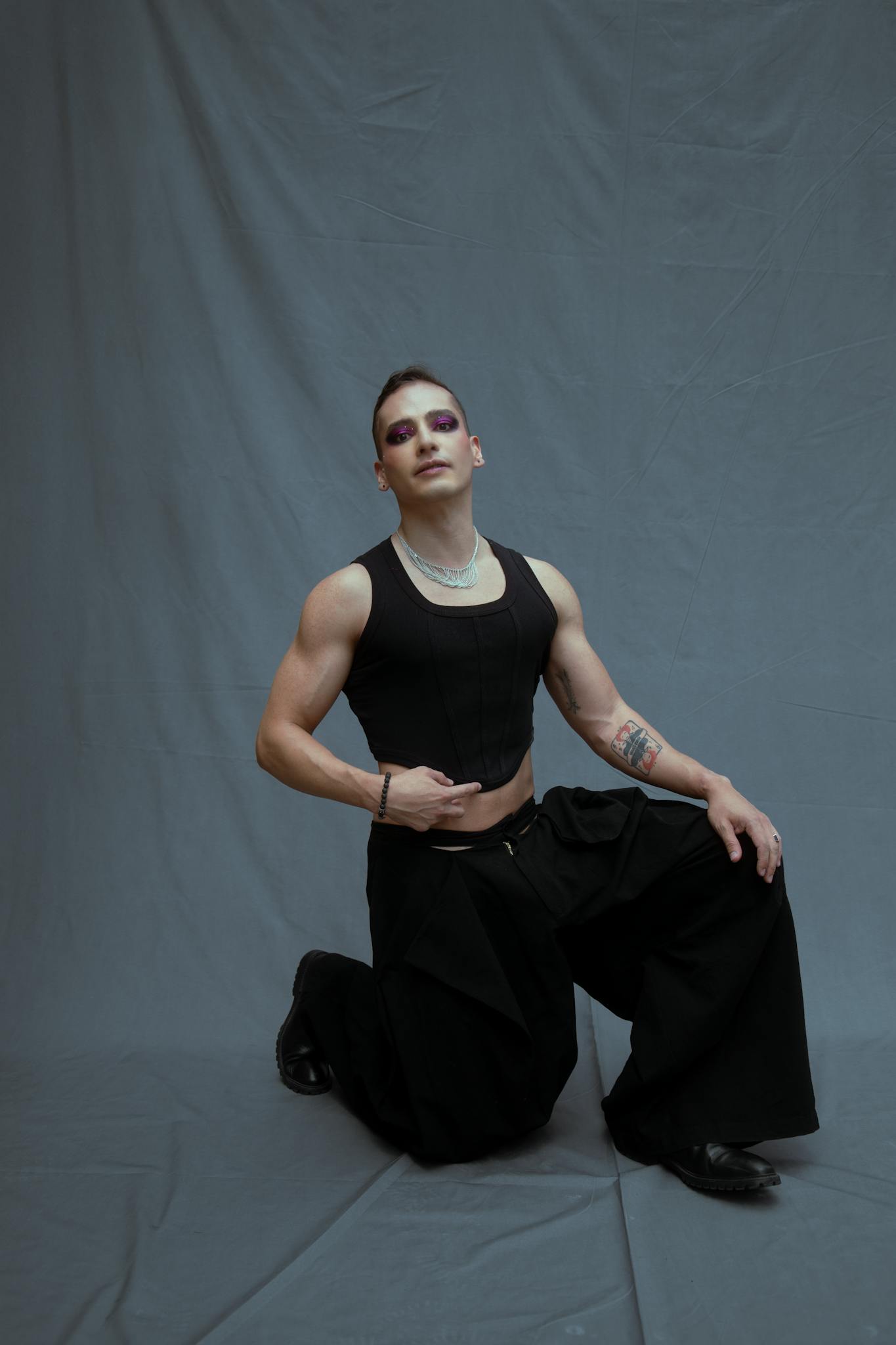 Bold portrait of a fashion-forward model in elegant black attire with dramatic makeup.