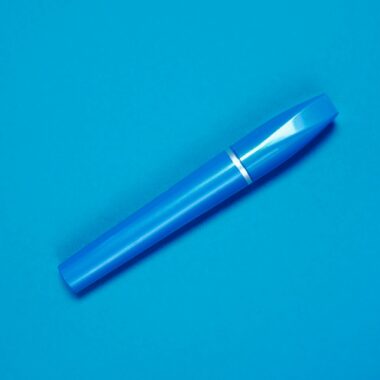 Close-up of a blue mascara tube set against a matching blue background, highlighting sleek design.