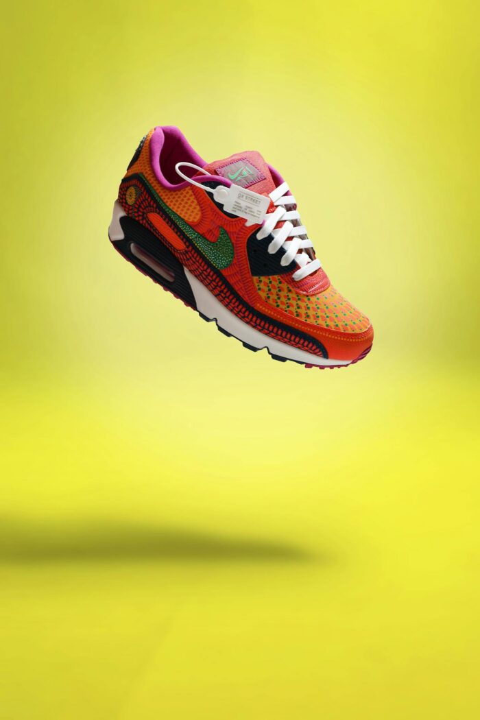 Colorful sneaker with shoelaces on a bright yellow background.
