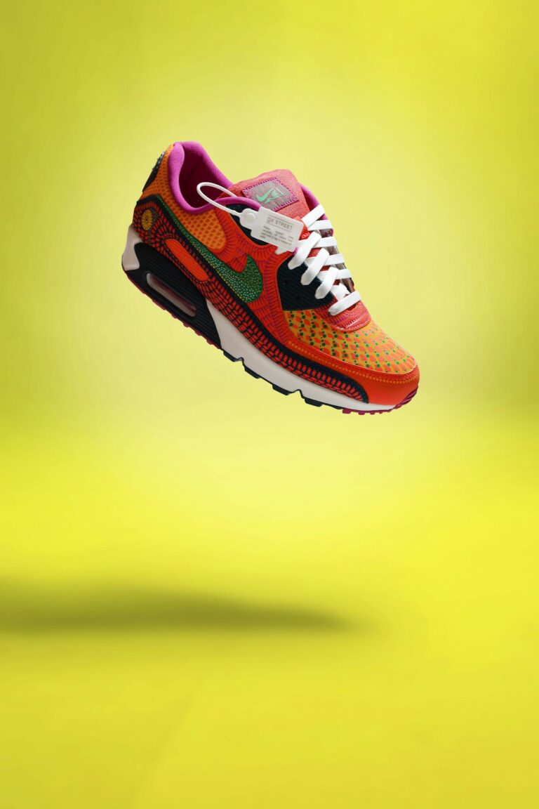 Colorful sneaker with shoelaces on a bright yellow background.
